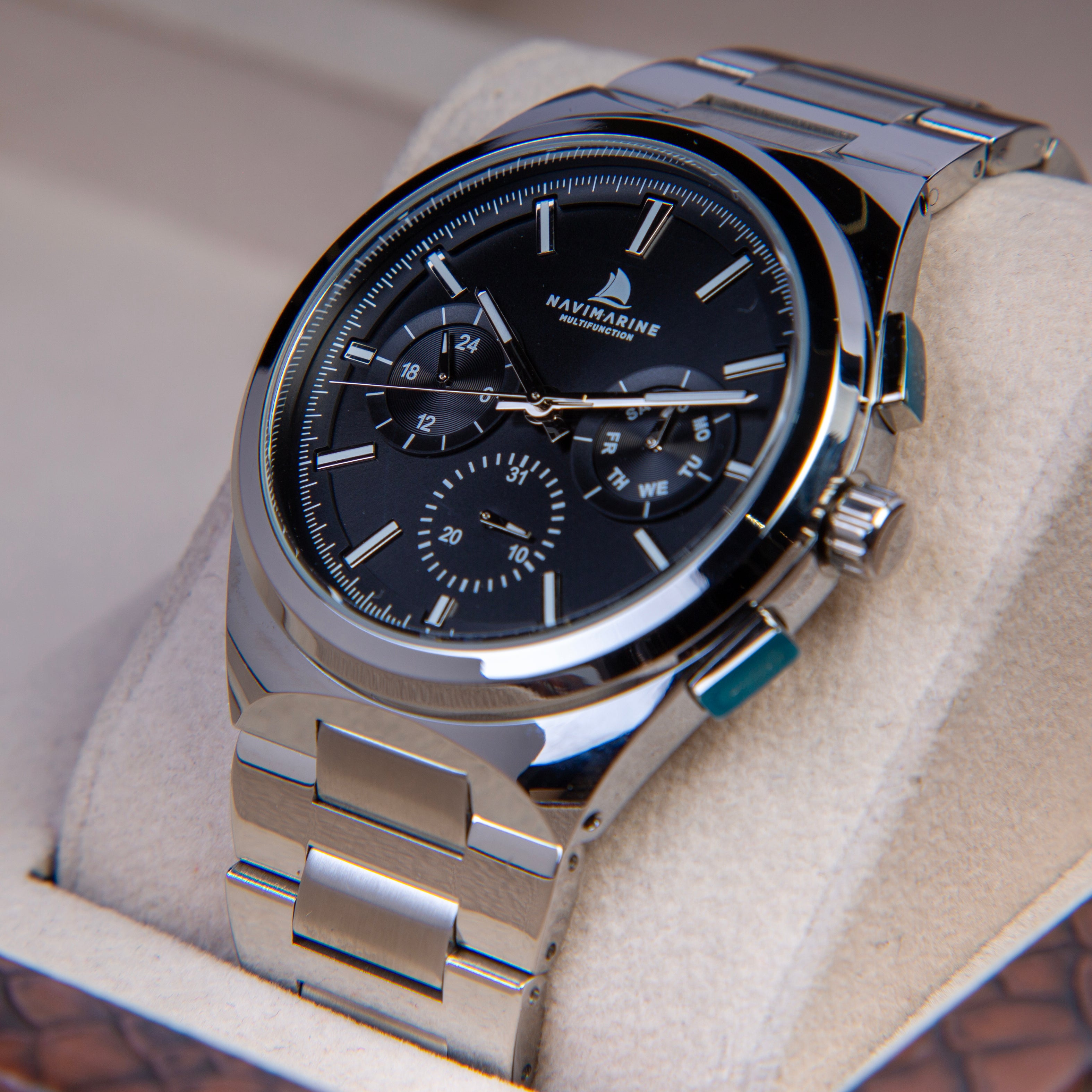 Silver wristwatch with black dial on a white cushion