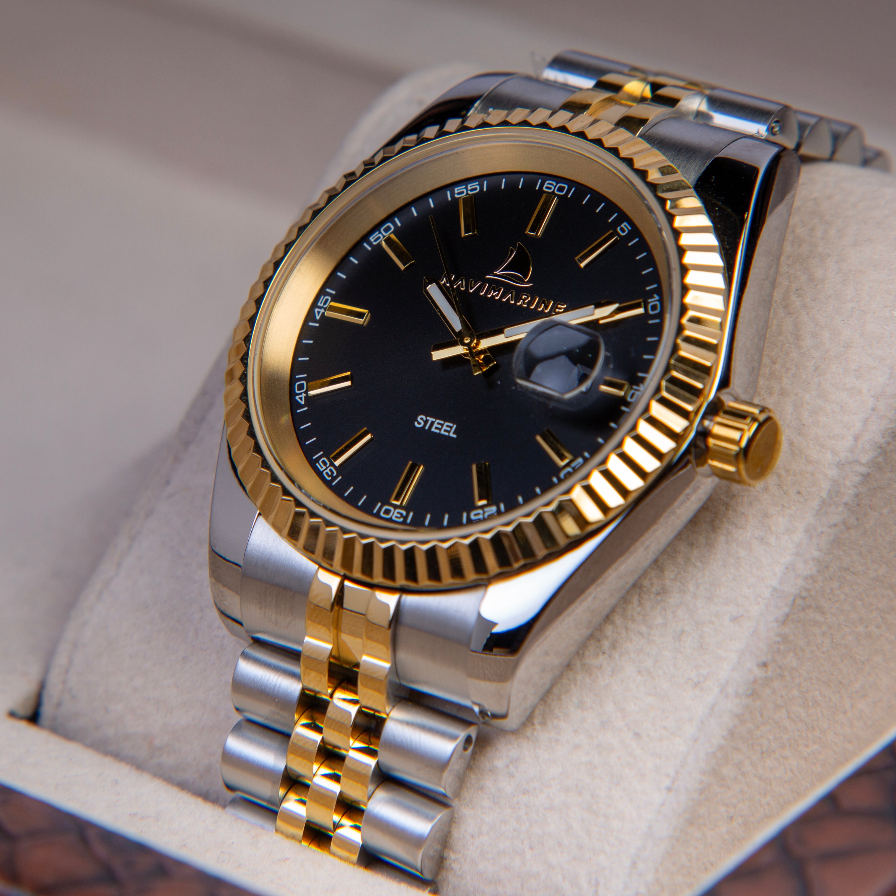 Luxury watch with gold and silver band on a light background