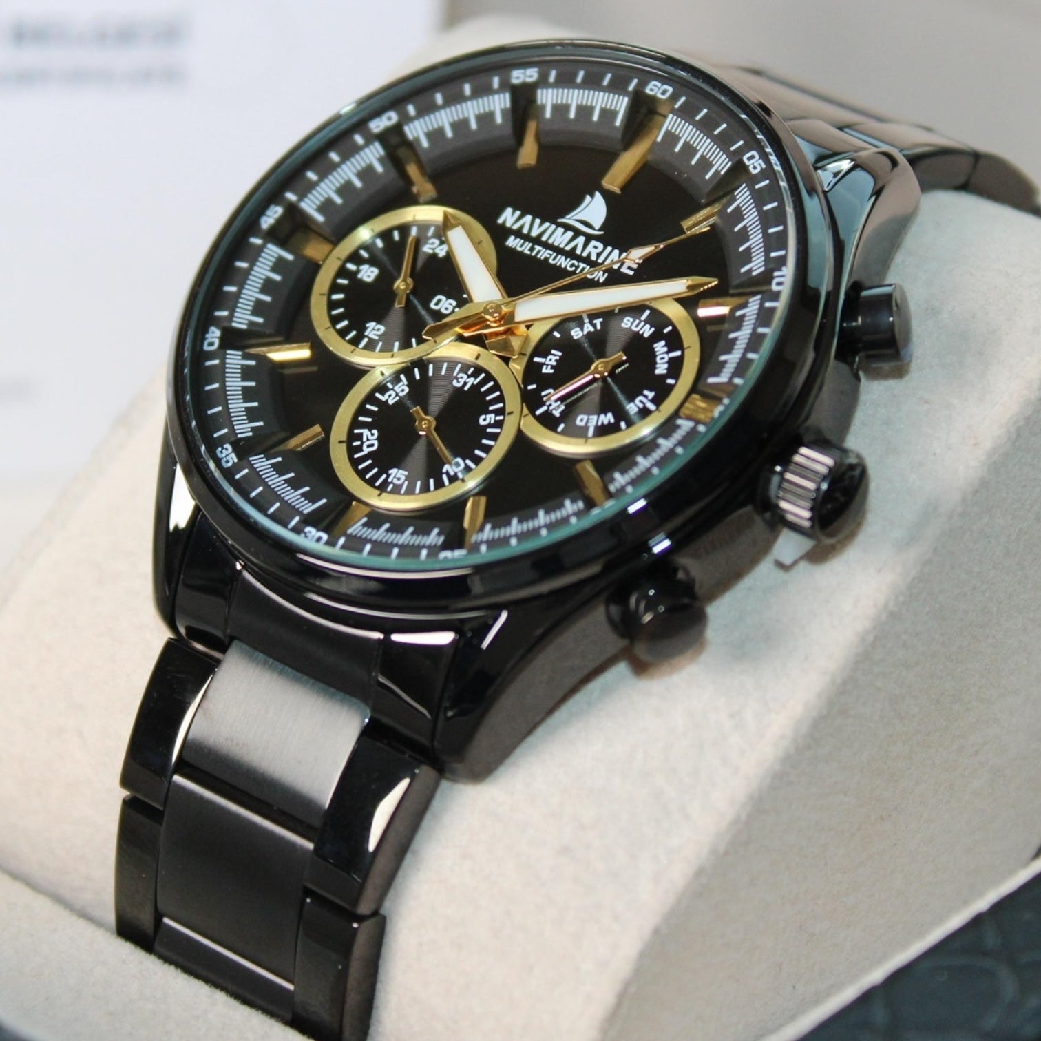 Black and gold Navimag watch on a white surface