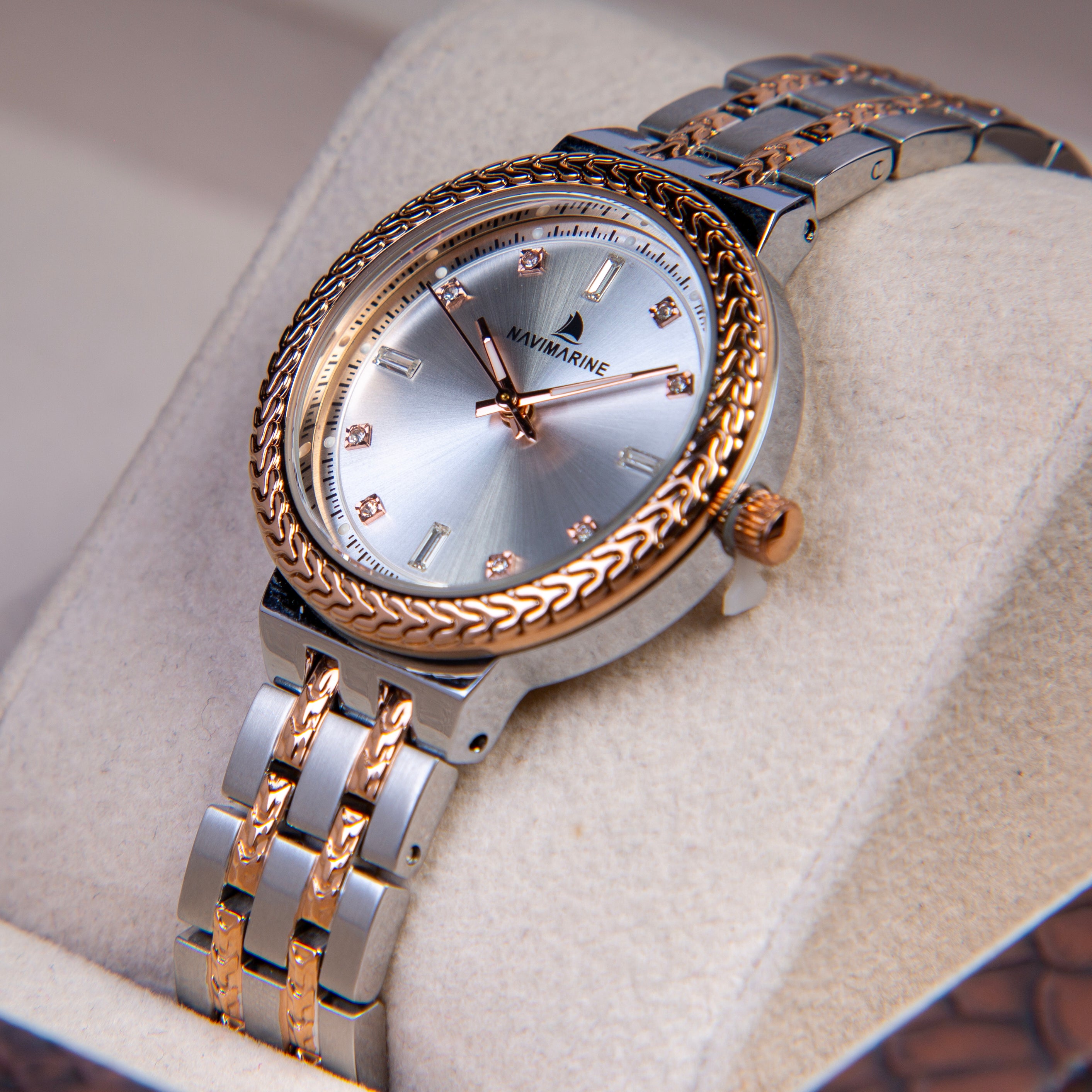 Luxury watch with silver and rose gold band on a light gray background