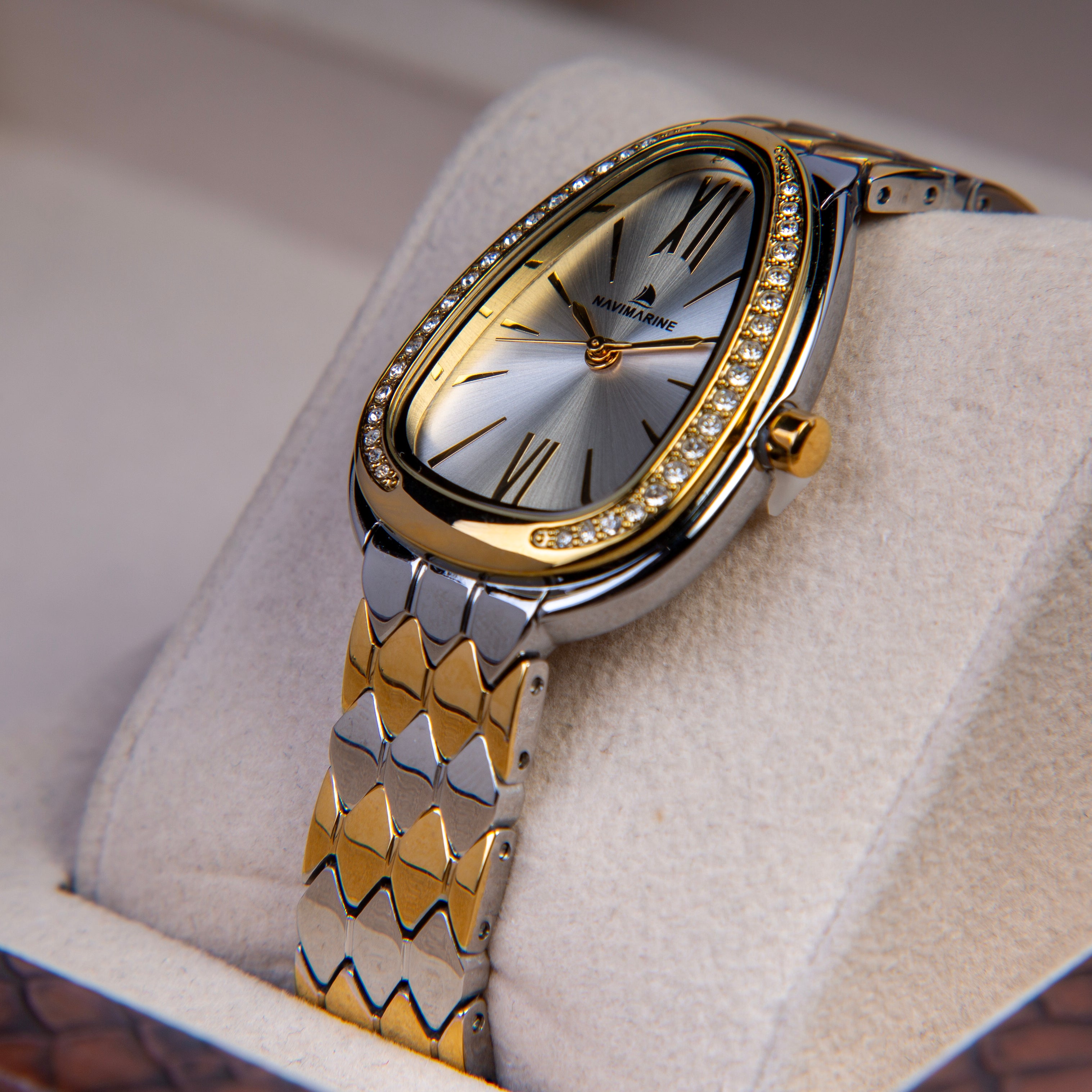 Gold and silver watch with diamond-studded bezel on a soft surface