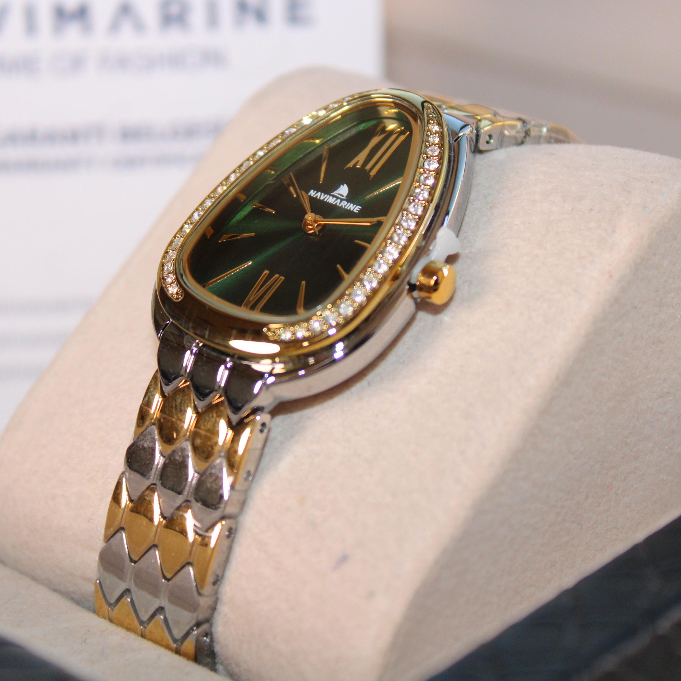 Luxury watch with gold and silver band on a white cushion, brand name visible