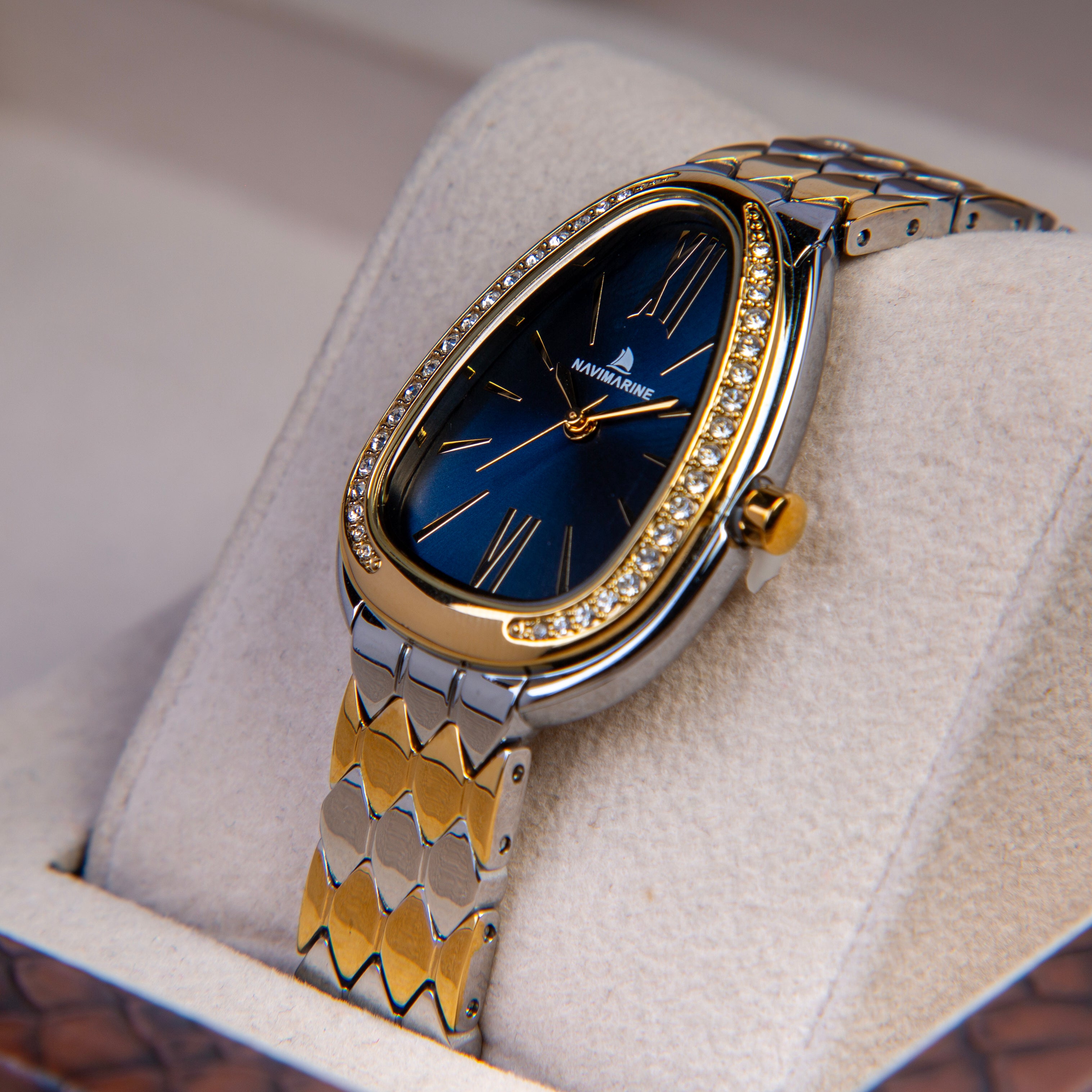 Luxury watch with a blue face and gold accents on a soft surface