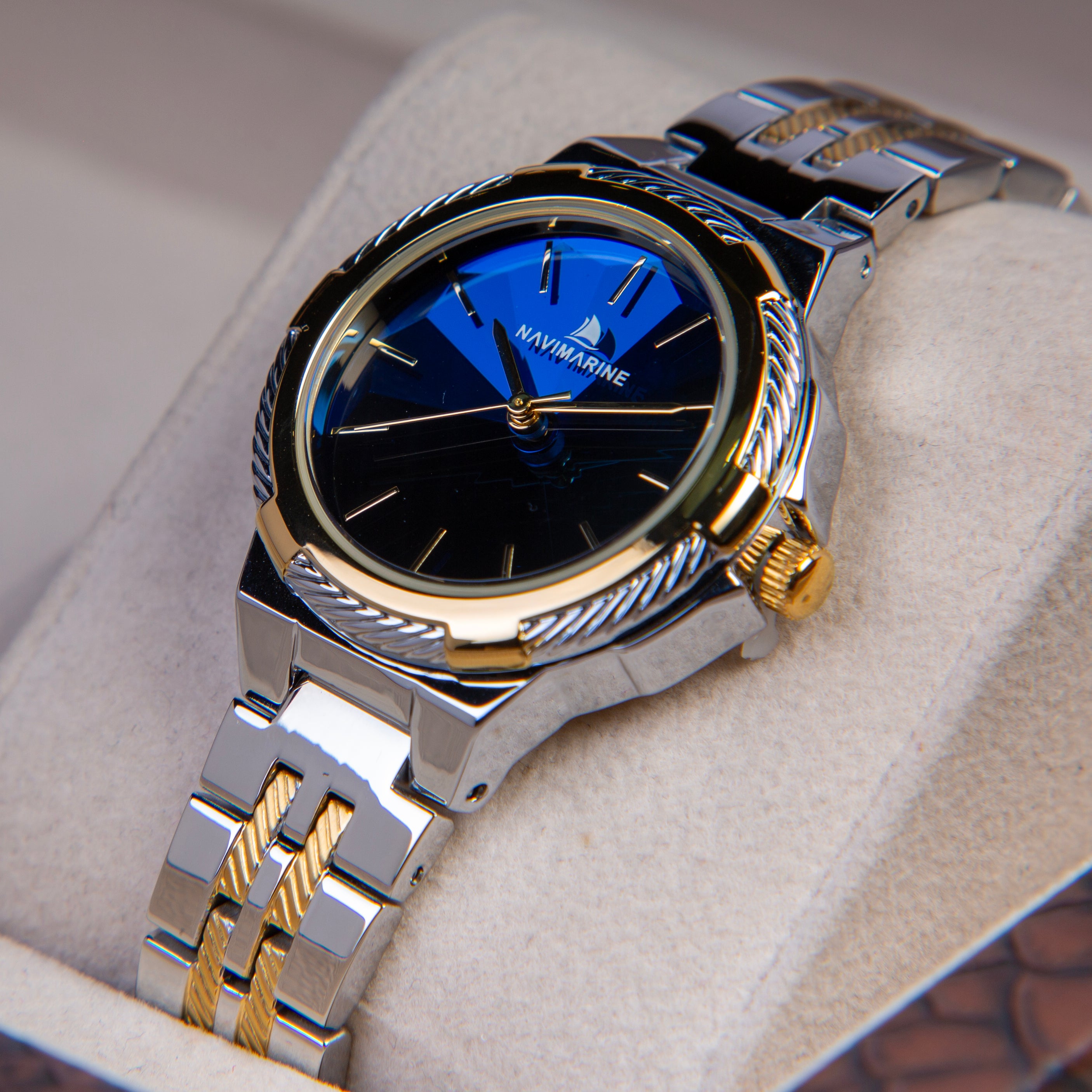 Silver and gold watch with blue face on a light gray background