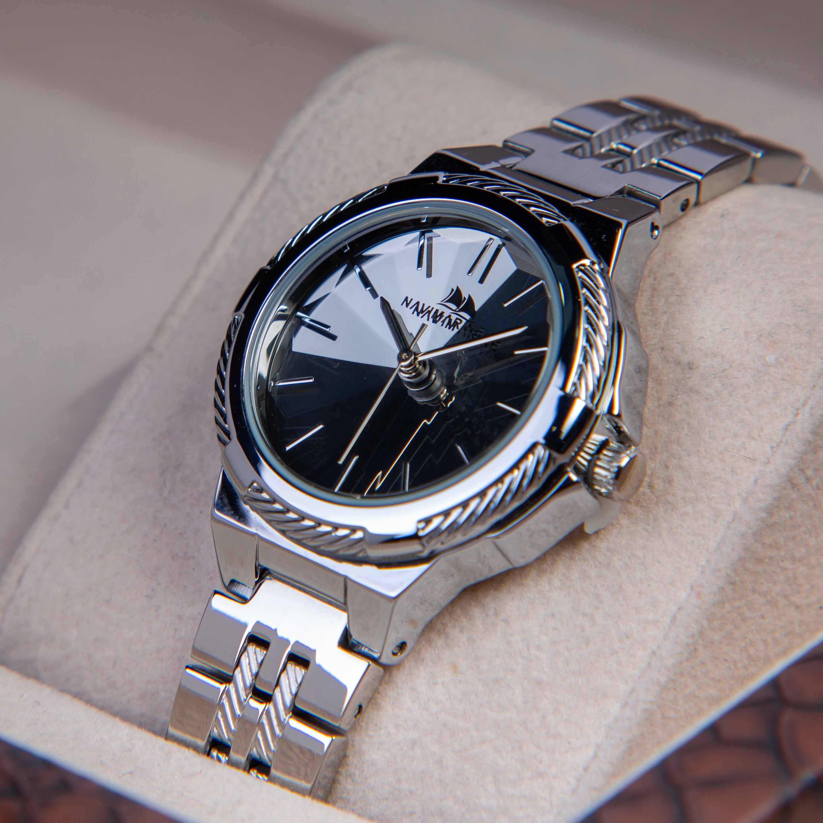 Silver wristwatch with black face on a soft surface