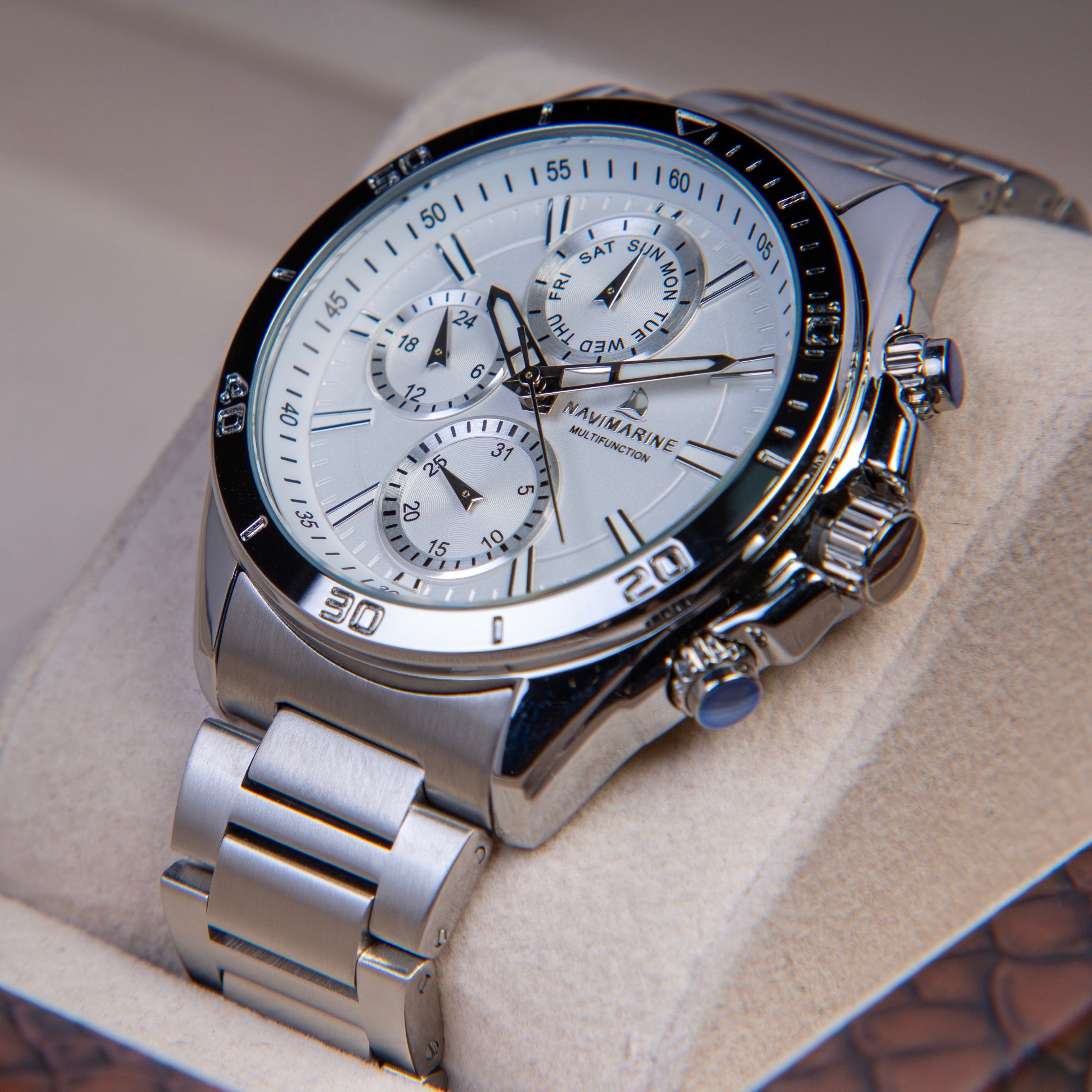 Silver wristwatch with a detailed face on a light background