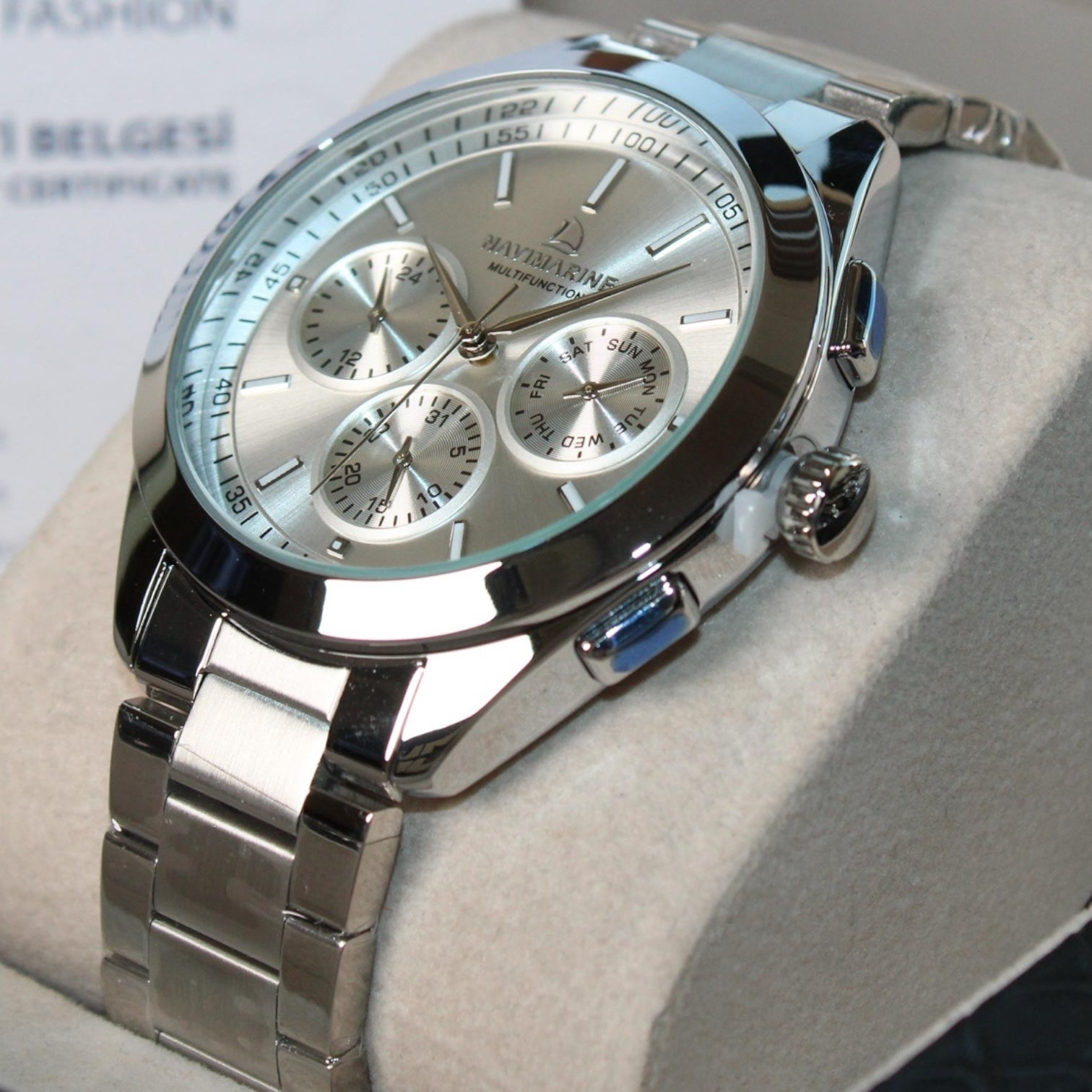 Silver wristwatch with detailed face on a light gray background