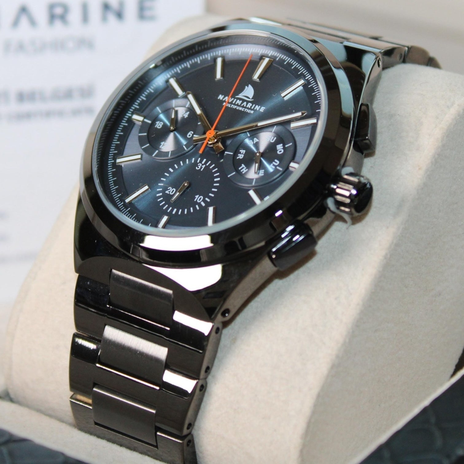 Black wristwatch with detailed face on a light gray surface