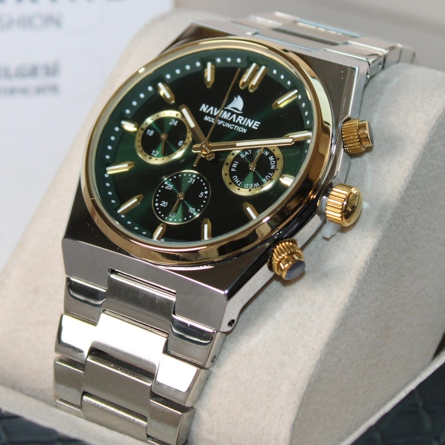 Navimagine watch with green face and gold accents on a white cushion