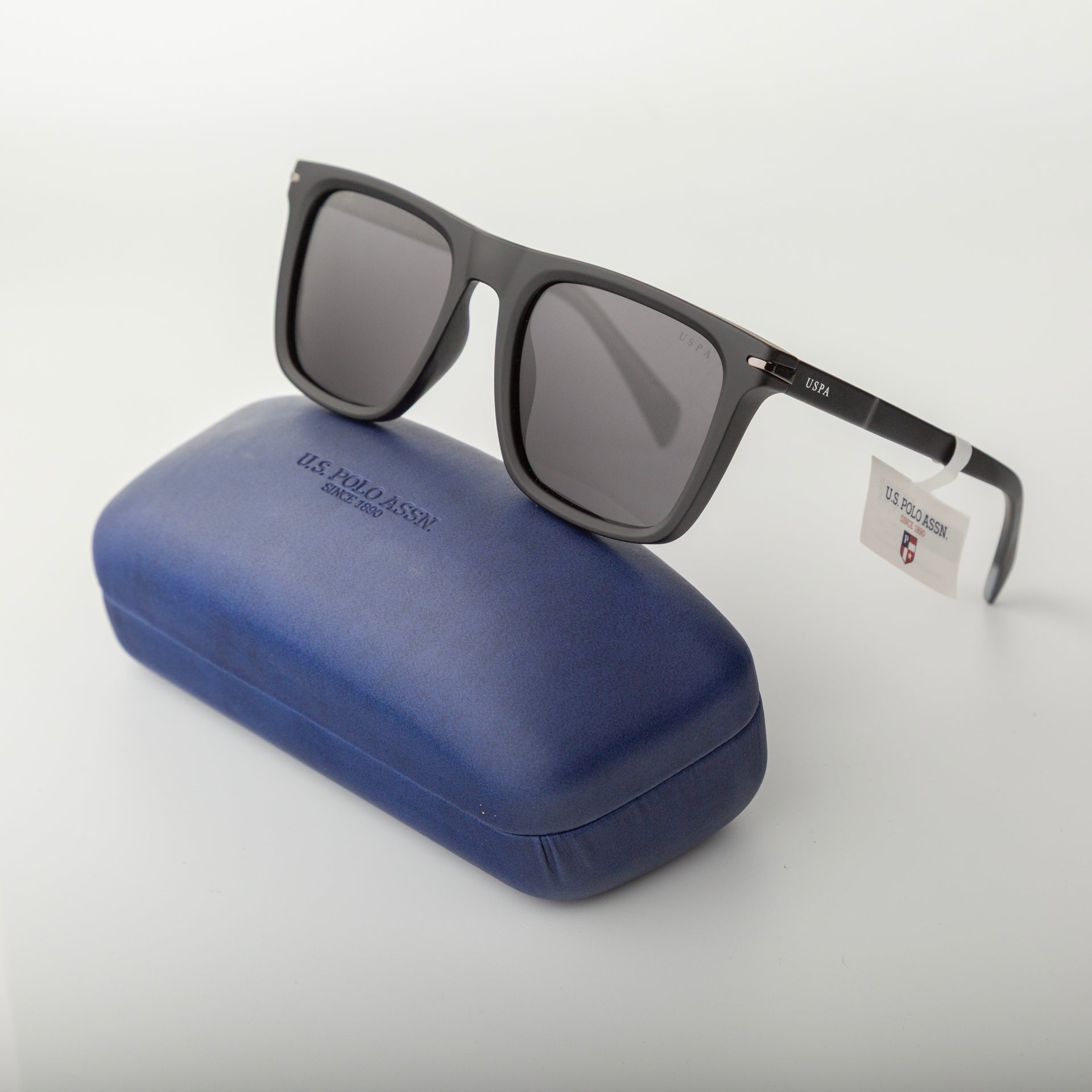 Black sunglasses with a blue case on a white background