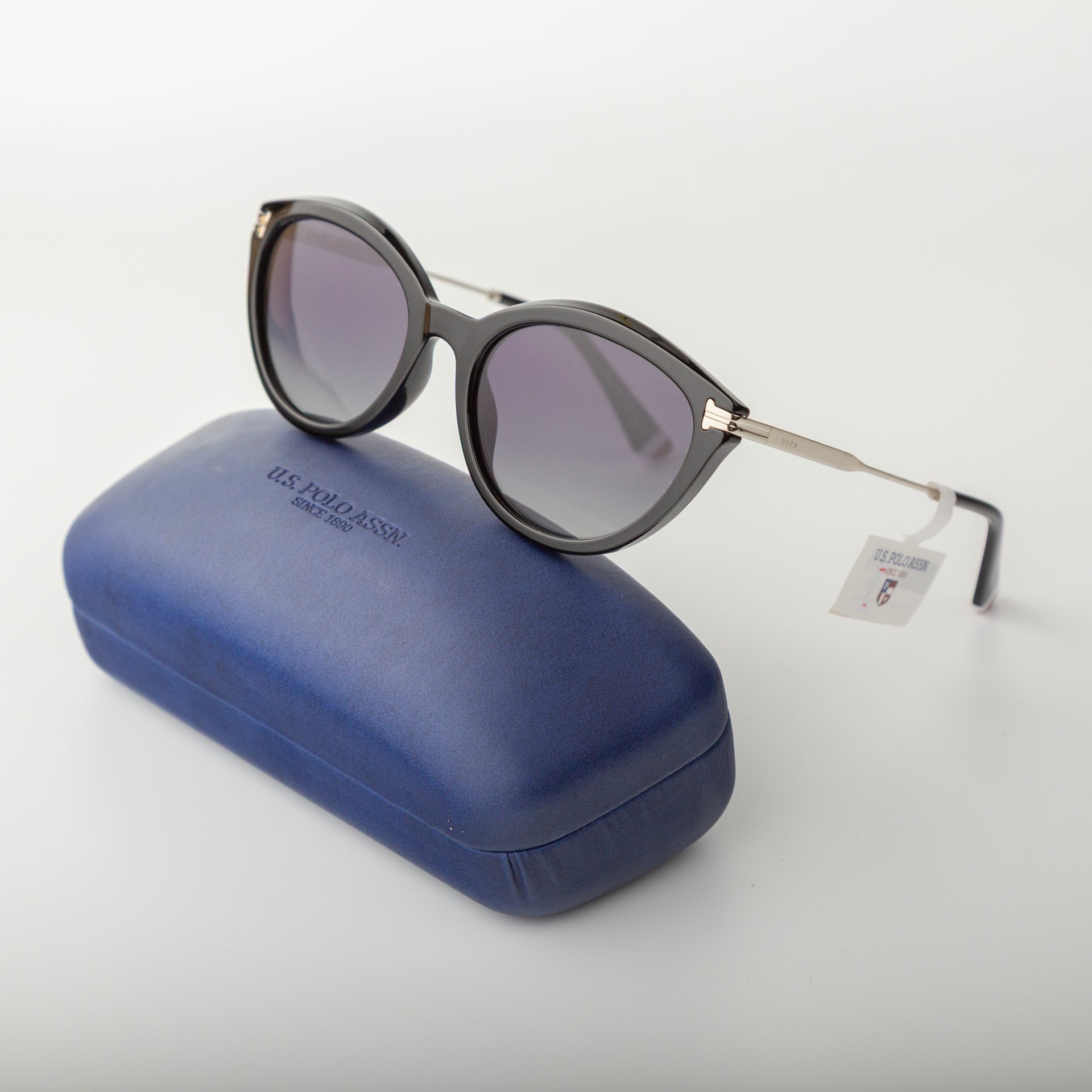 Sunglasses with a blue case on a light gray background