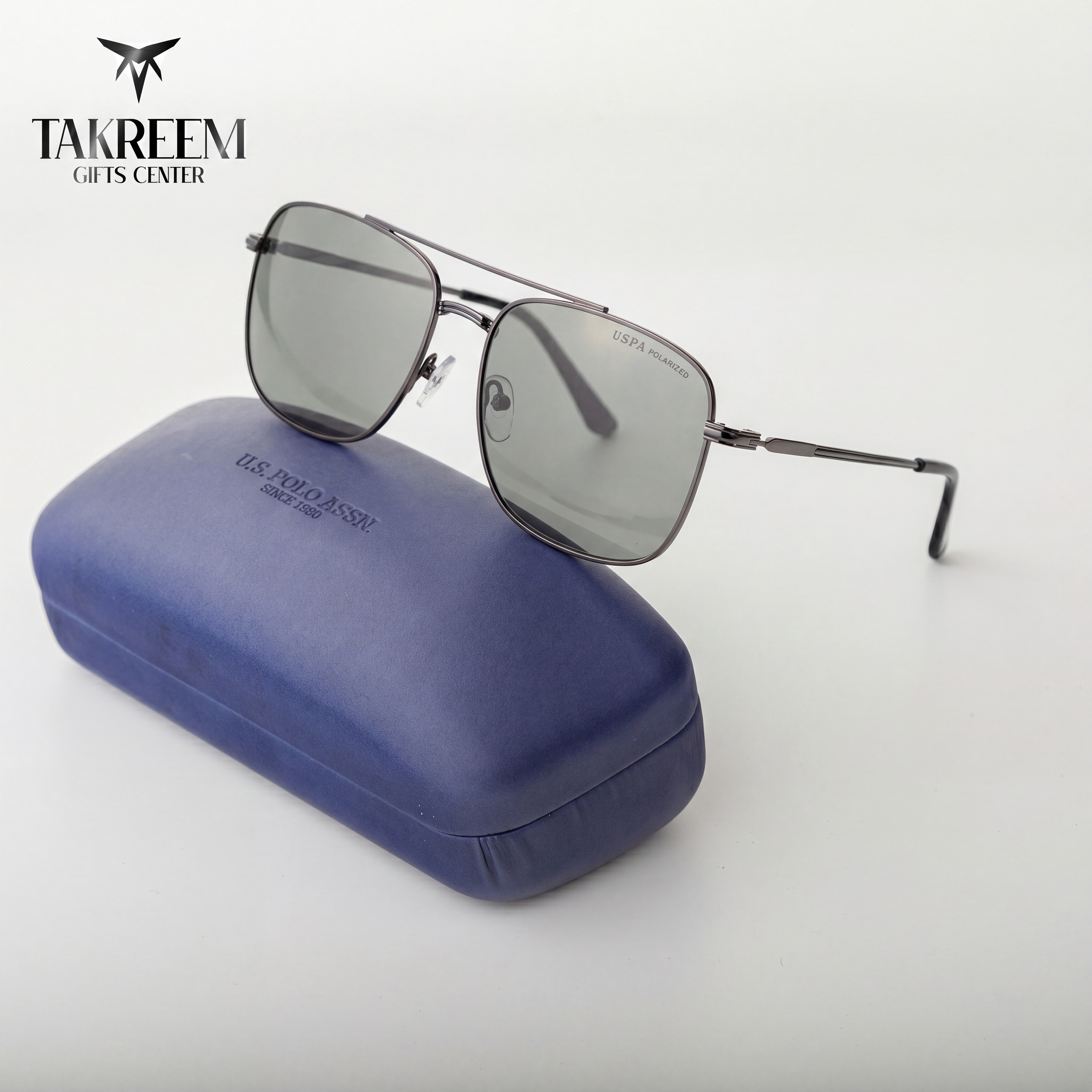 Sunglasses with a blue case on a white background, featuring the Takreem Gifts Center logo.