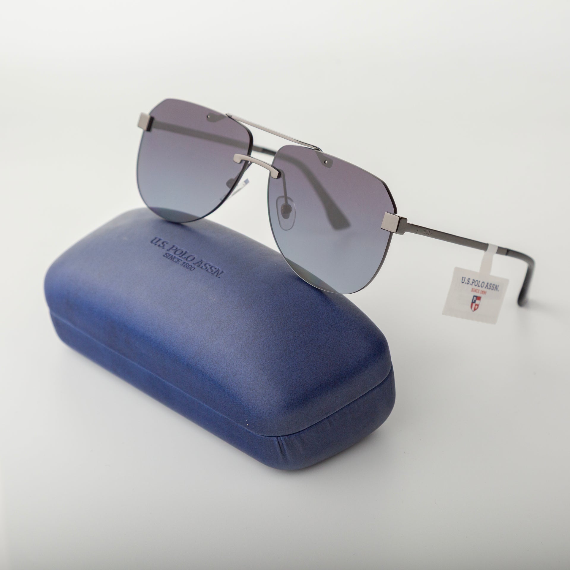 Sunglasses with gradient lenses on a blue case against a white background