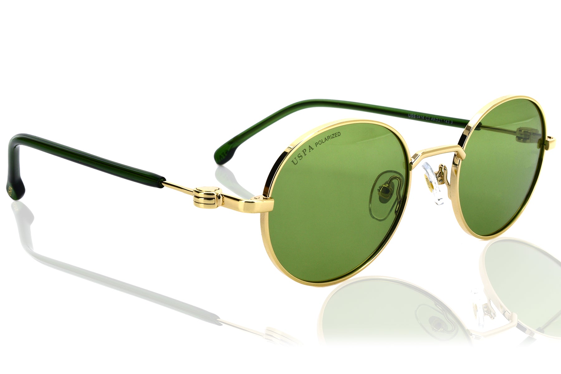 Round sunglasses with gold frames and green lenses on a white background