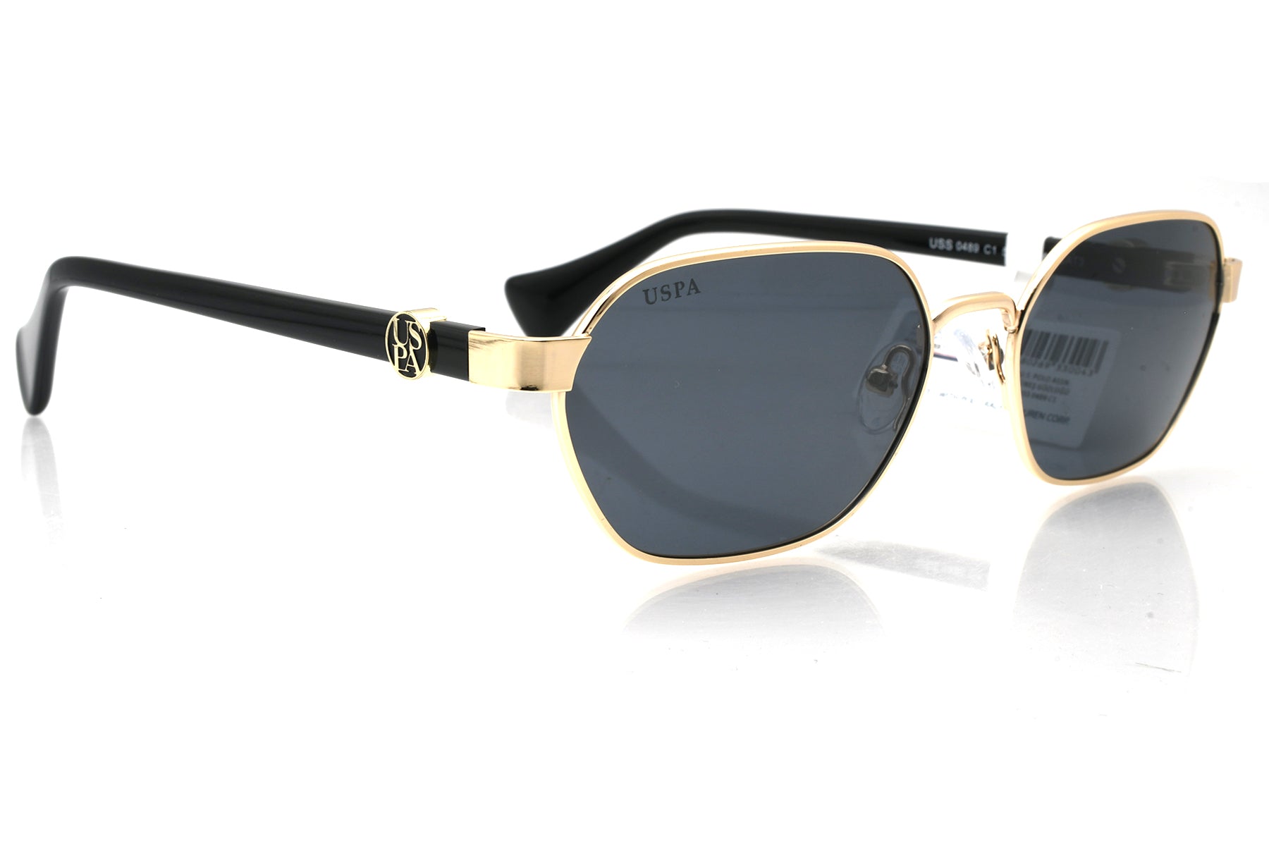 Sunglasses with gold frame and black arms on a white background