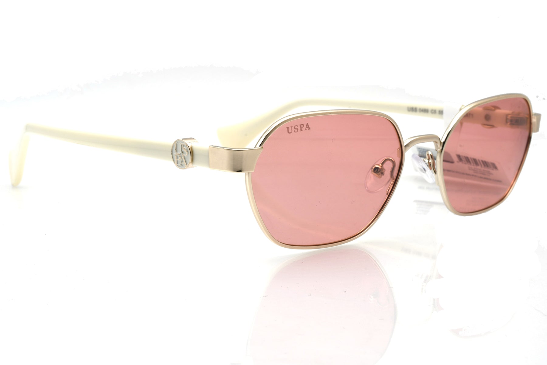 Sunglasses with pink lenses and gold frame on a white background