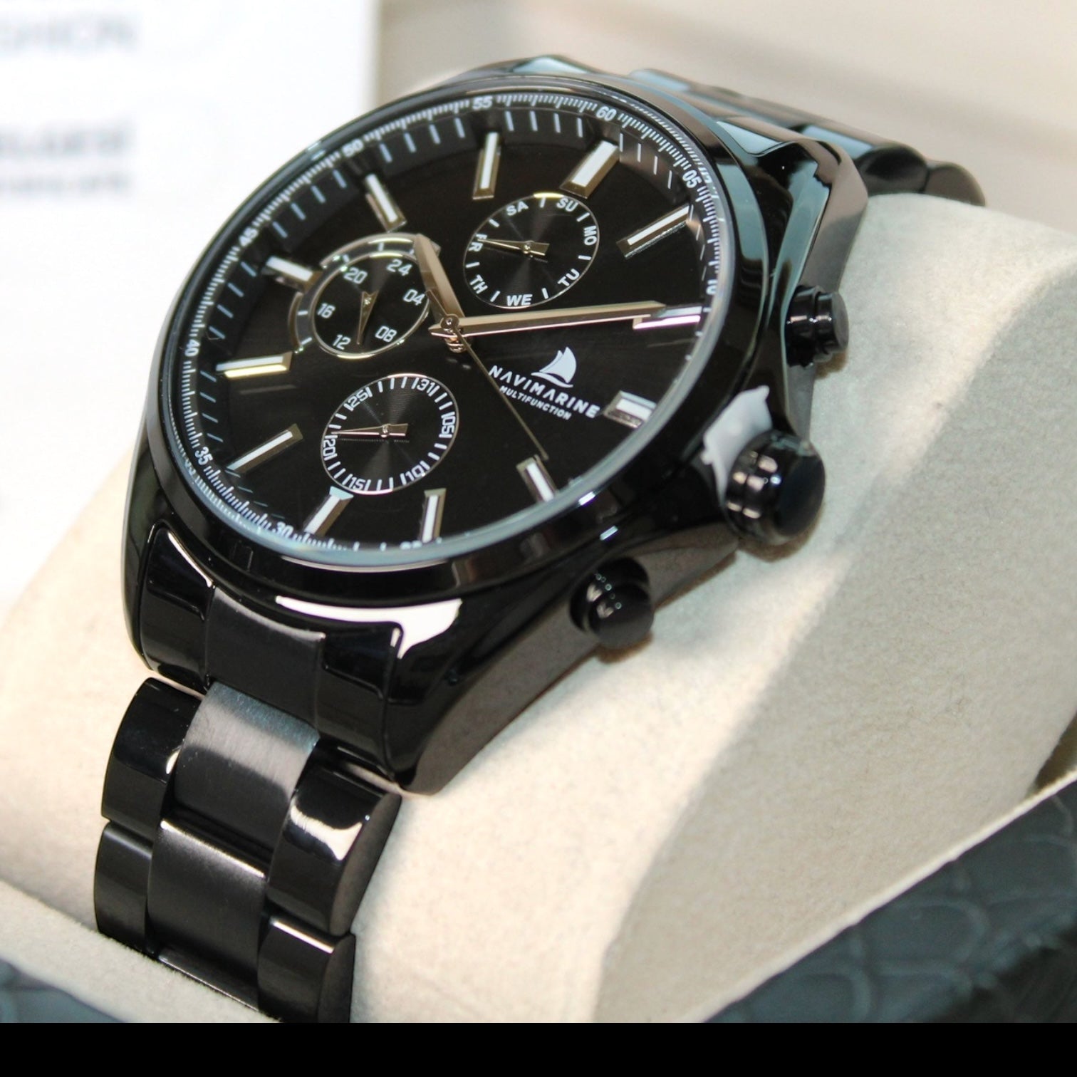 Black wristwatch with detailed face on a white surface
