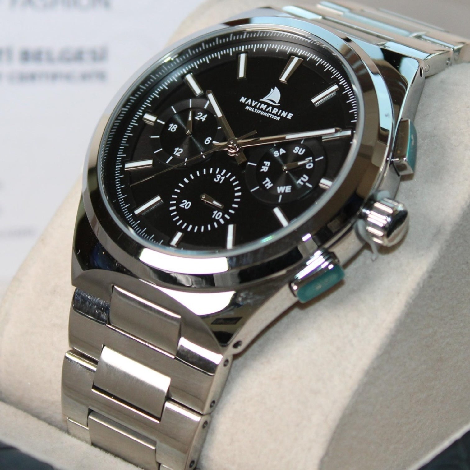 Silver watch with black face on a light gray surface
