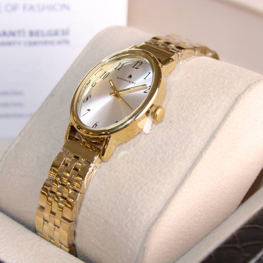 Gold wristwatch on a white cushion with a blurred background