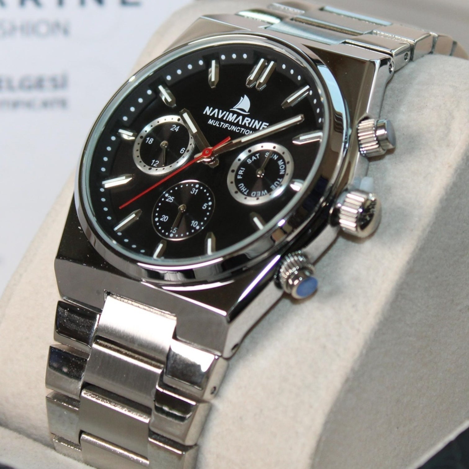Silver NaviMarine watch with black dial on a light gray surface