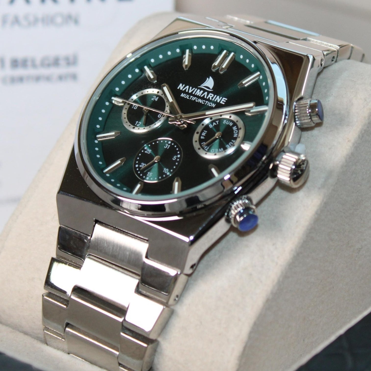 Navimagine watch with silver band and green dial on a light gray surface