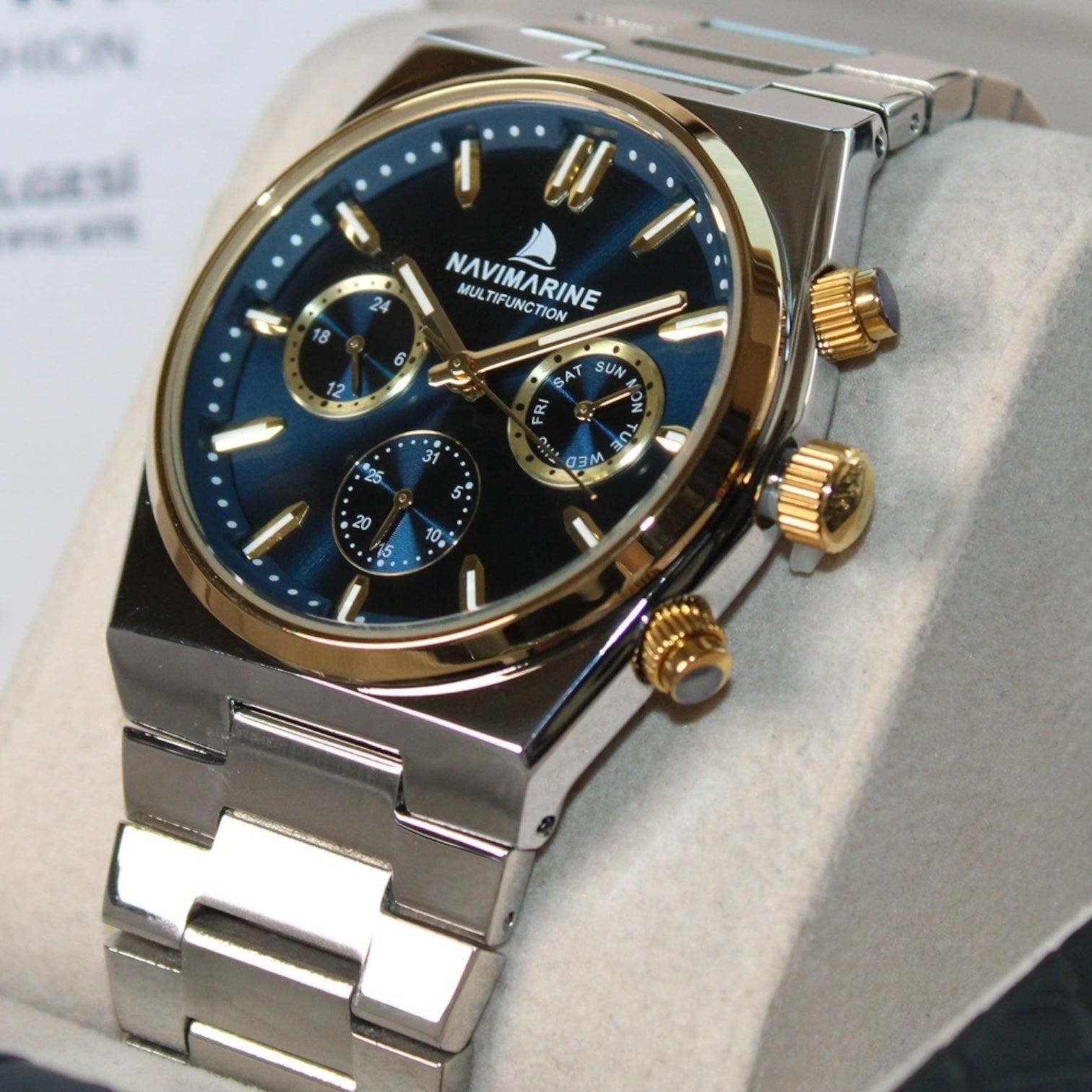 Luxury watch with blue dial and gold accents on a light gray background