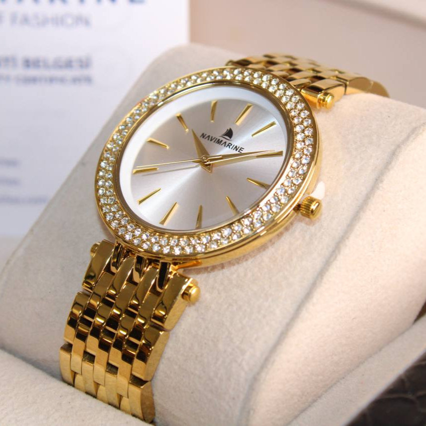 Gold wristwatch with diamond-studded bezel on a white cushion