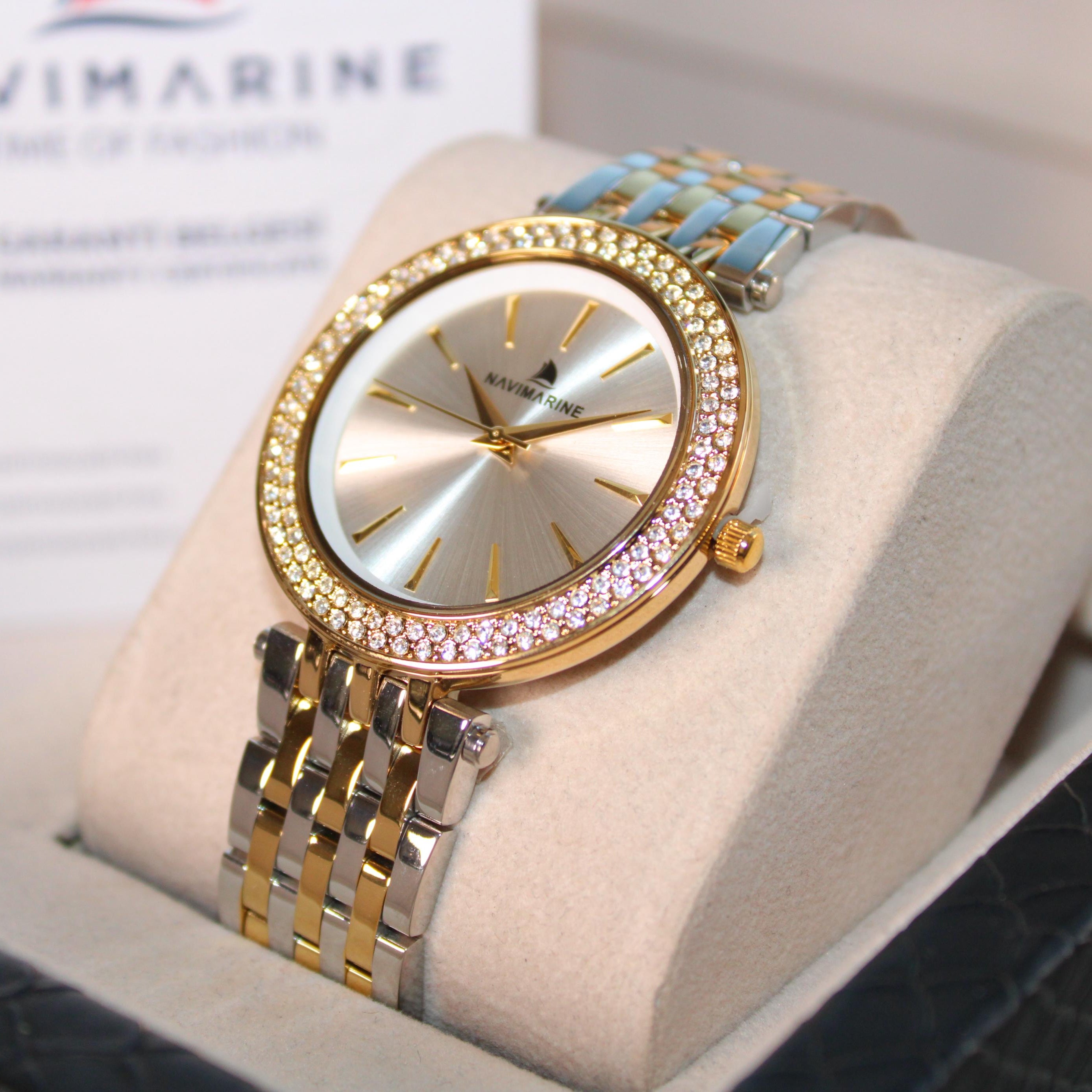 Luxury watch with a gold and silver band on a display stand, branded 'Navimarine'.