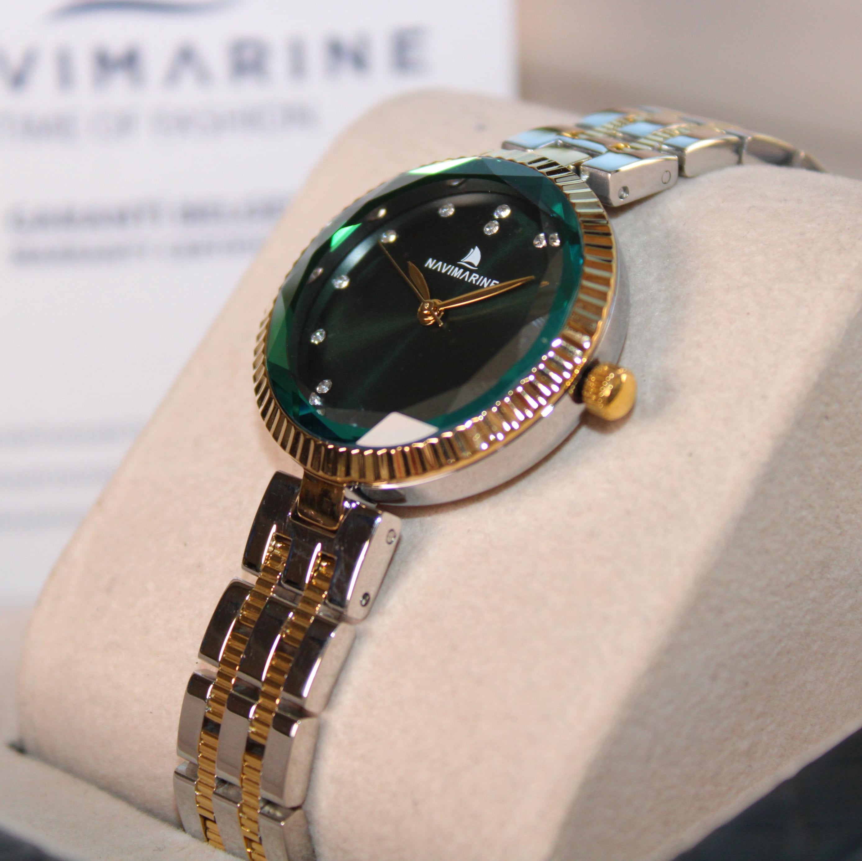 Navimarine watch with green face and gold accents on a white cushion