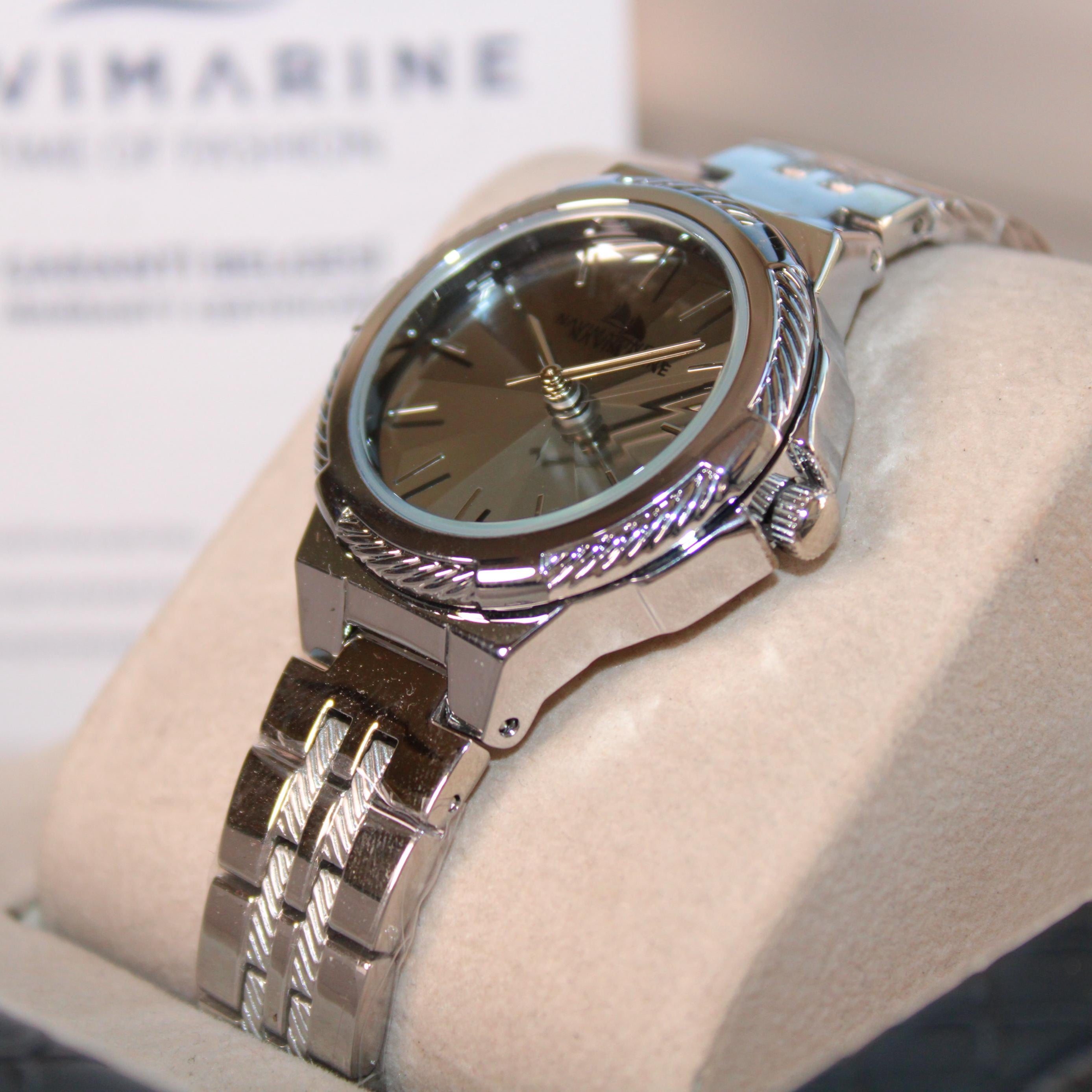 Silver wristwatch on a white cushion with a blurred background