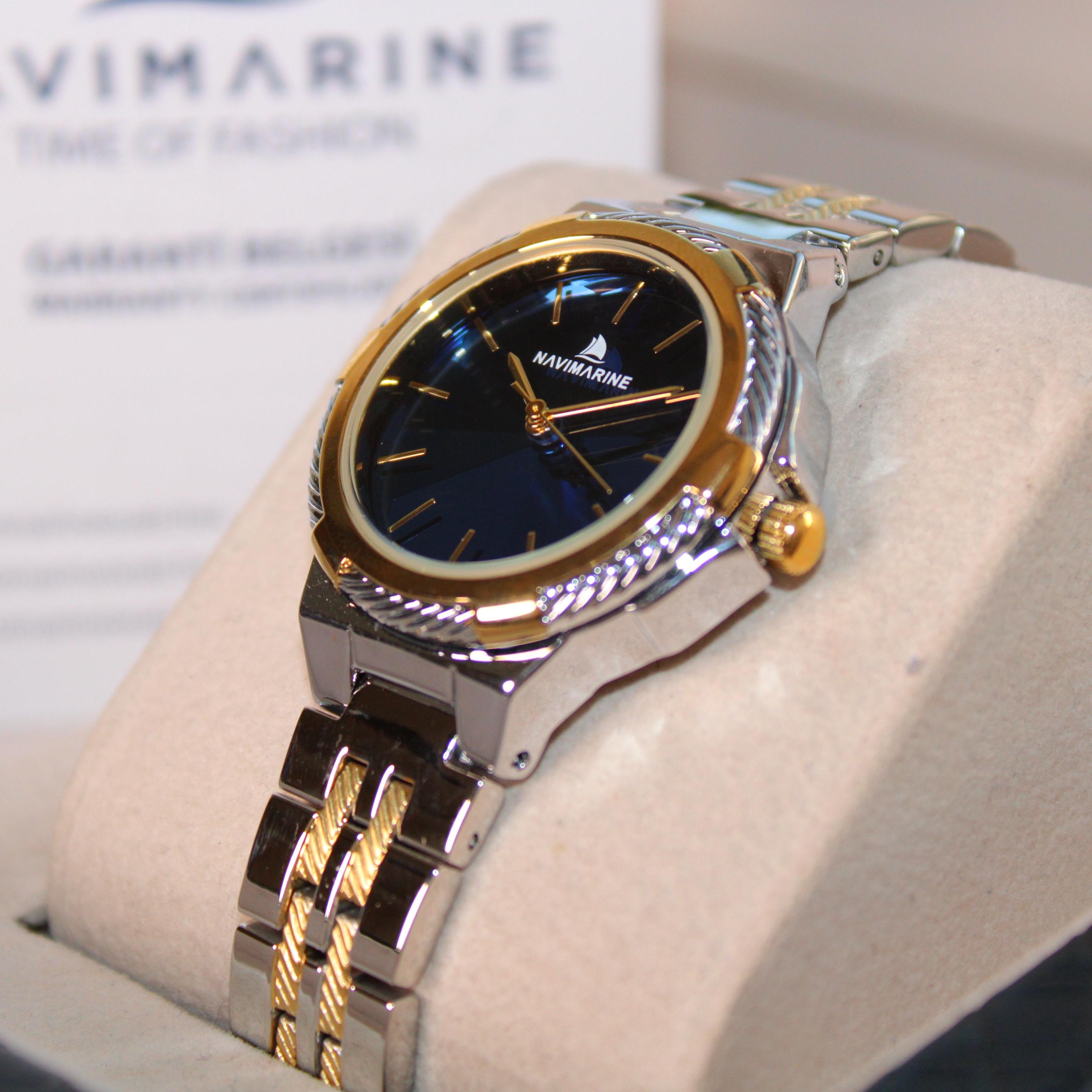Navimagine watch with gold and silver band on a white cushion