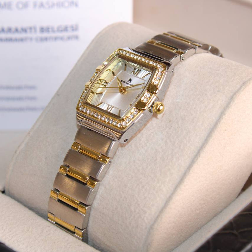 Gold and silver watch on a display stand with a blurred background