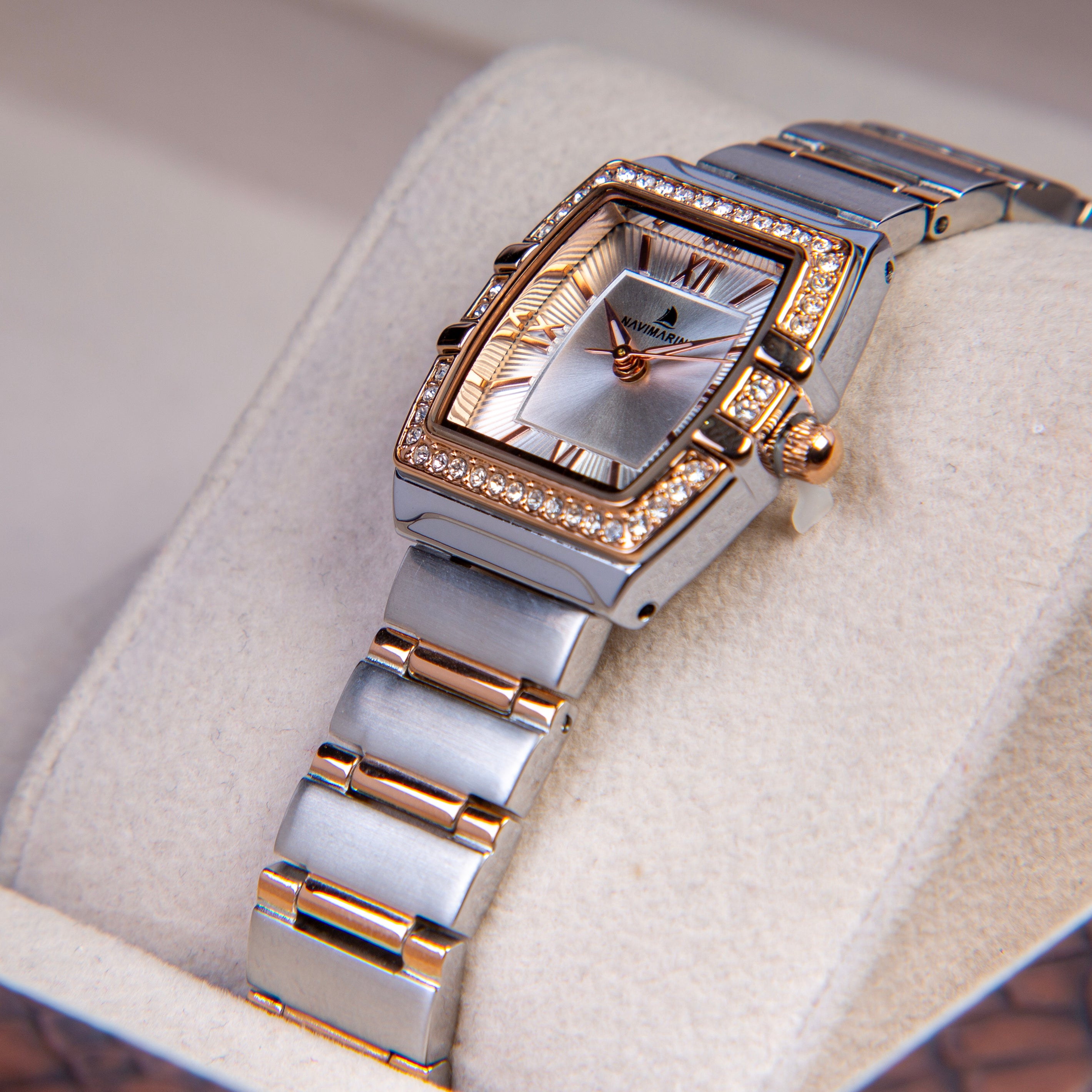 Luxury watch with rose gold and silver band on a soft surface