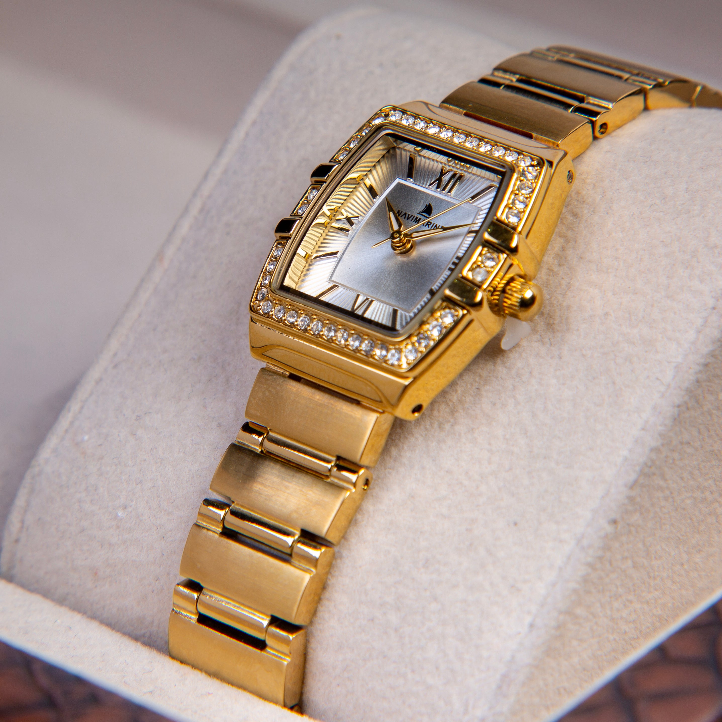 Gold wristwatch with diamond-studded face on a white cushion