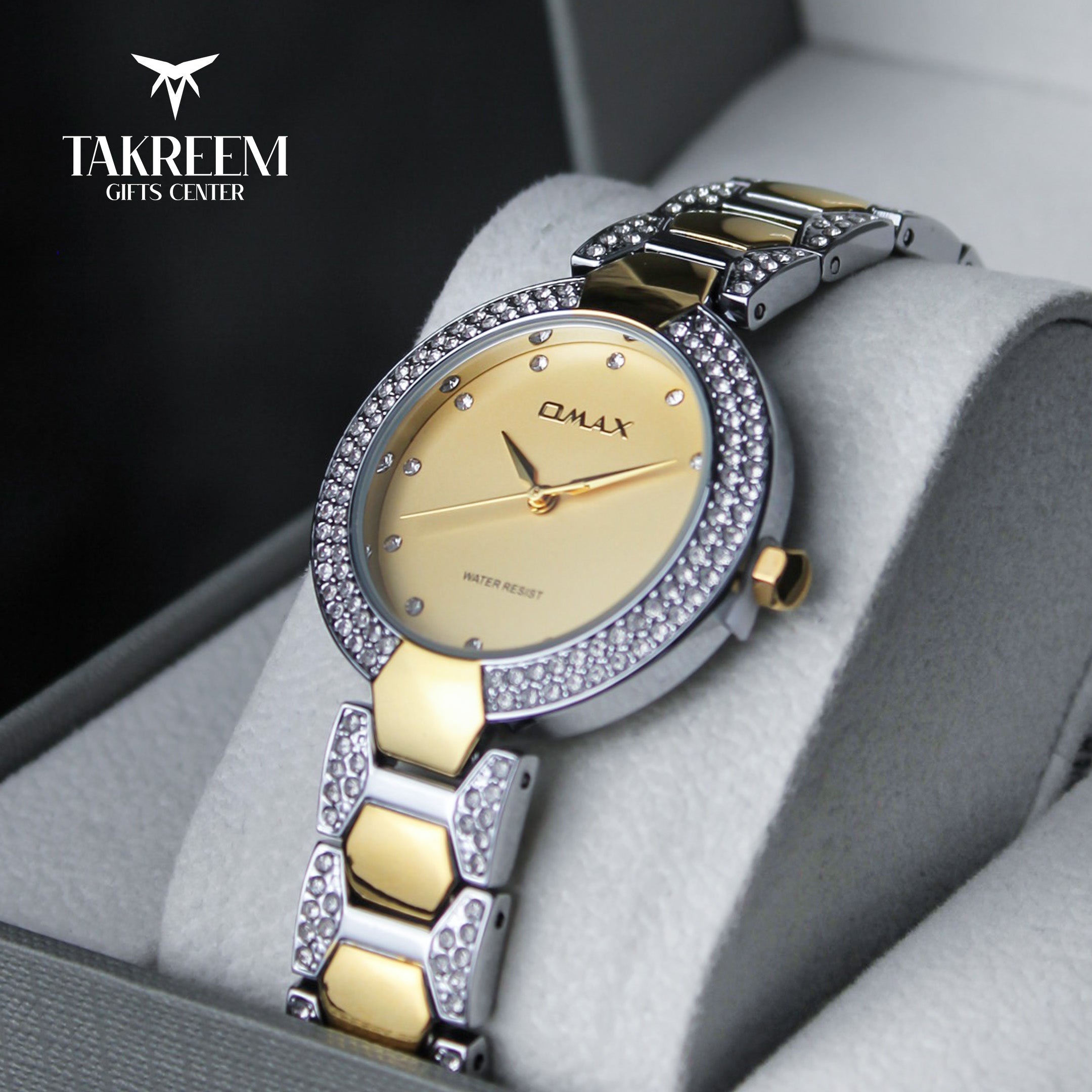 Luxury two-tone watch with gold and silver band on a gray cushion, brand 'Takreem' visible.
