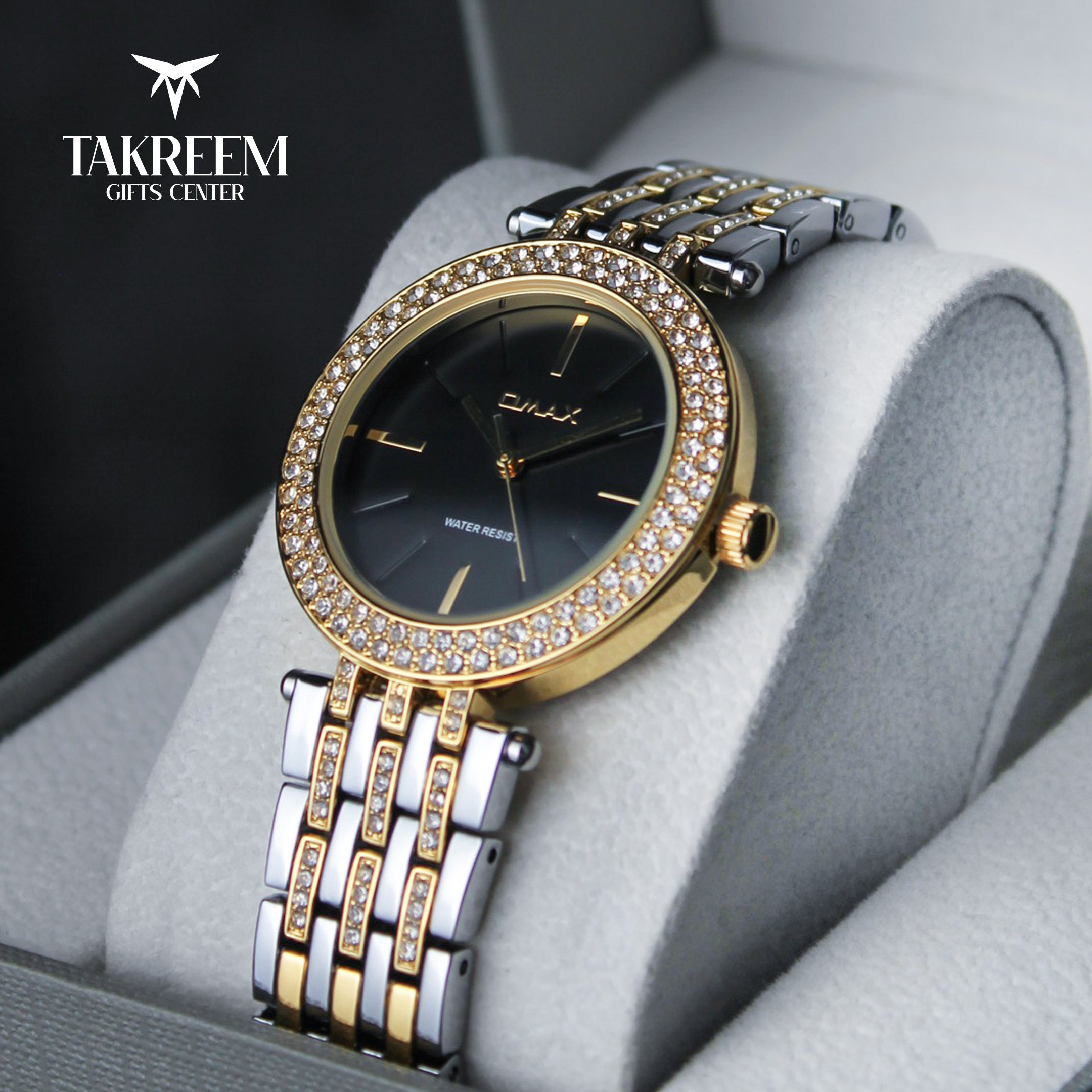 Luxury watch with gold and silver band on a gray cushion, branded 'Takreem Gifts Center'.