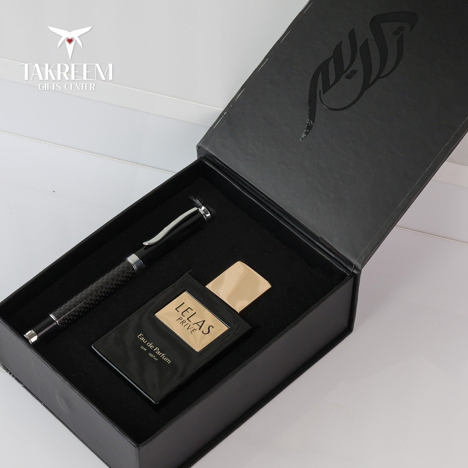 Perfume bottle and pen set in a black box with 'Takreem' branding.