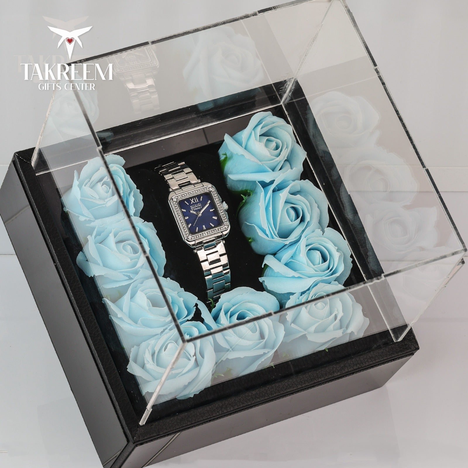 Silver watch in a box with blue roses, brand 'Takreem' visible