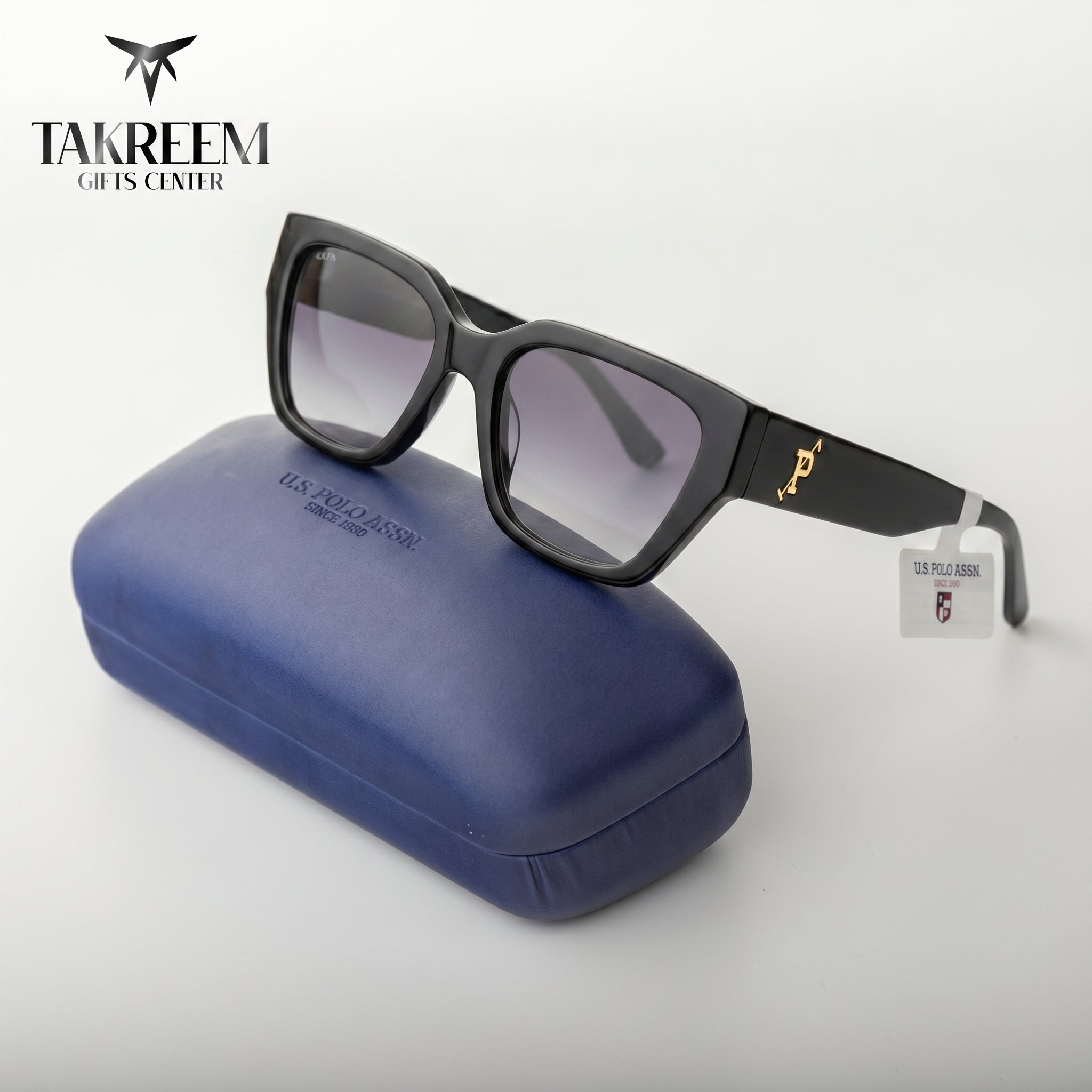 Black sunglasses with a blue case on a white background, featuring the Takreem Gifts Center logo.