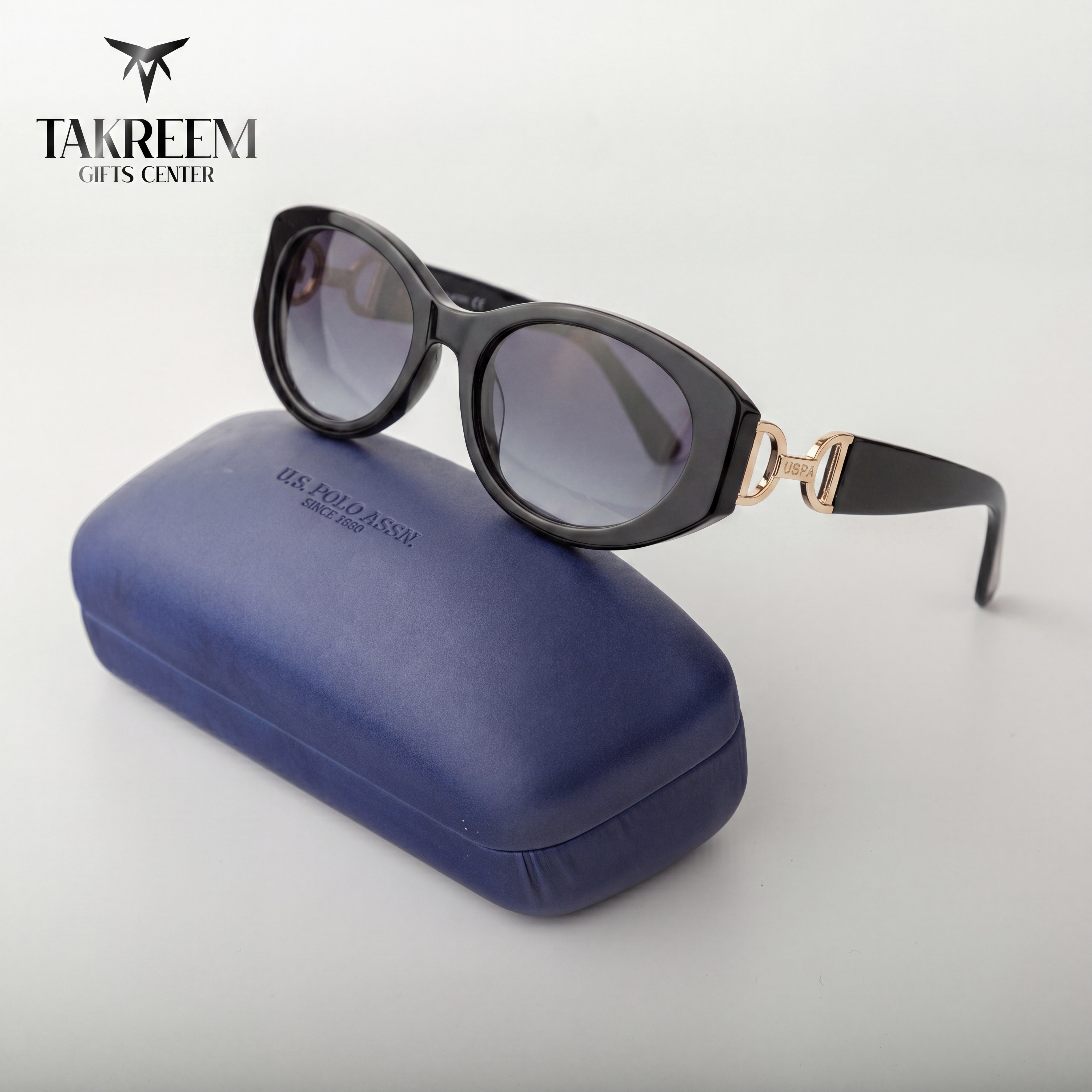 Sunglasses with a blue case on a white background, featuring the Takreem Gifts Center logo.