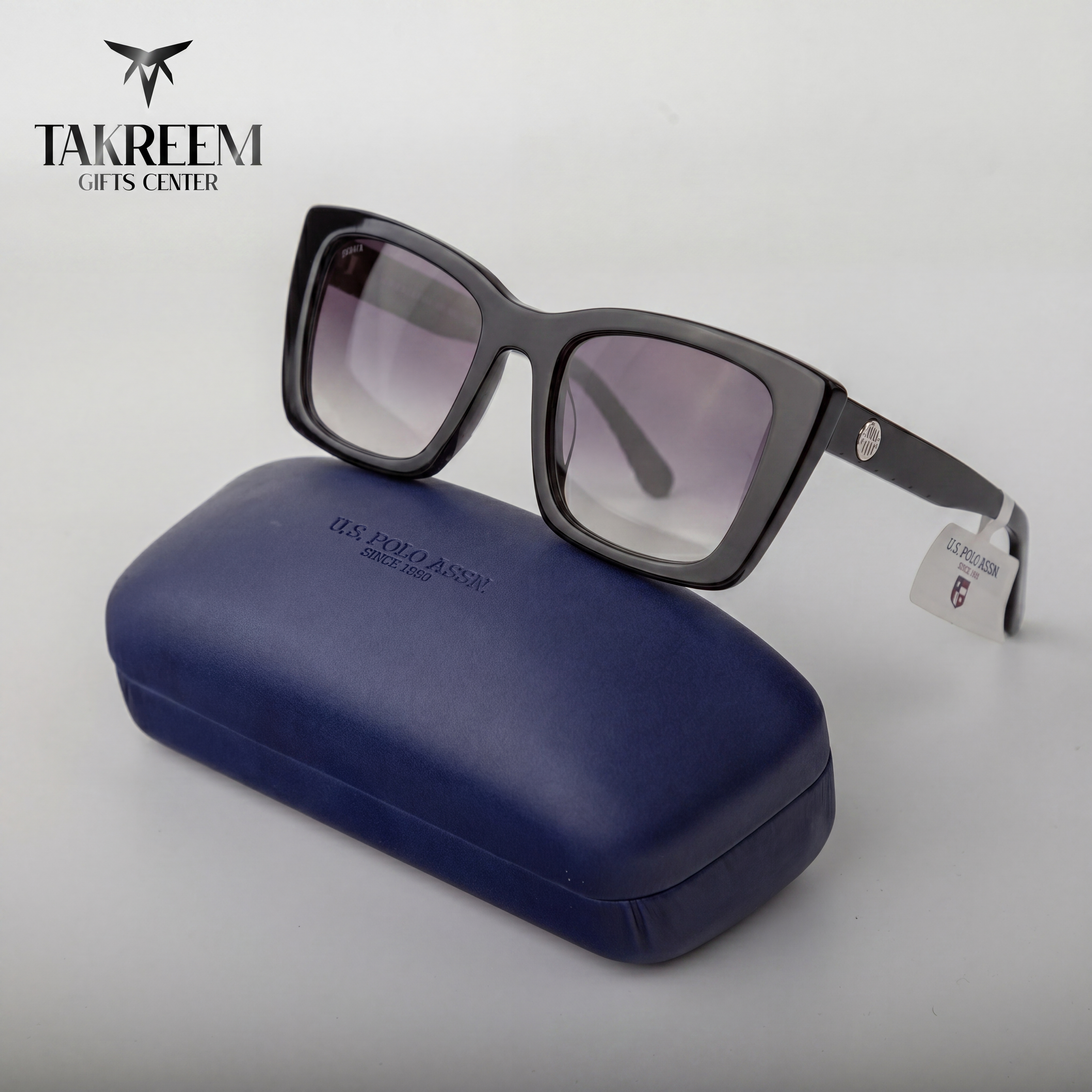 Sunglasses with a blue case on a white background, featuring the Takreem Gifts Center logo.