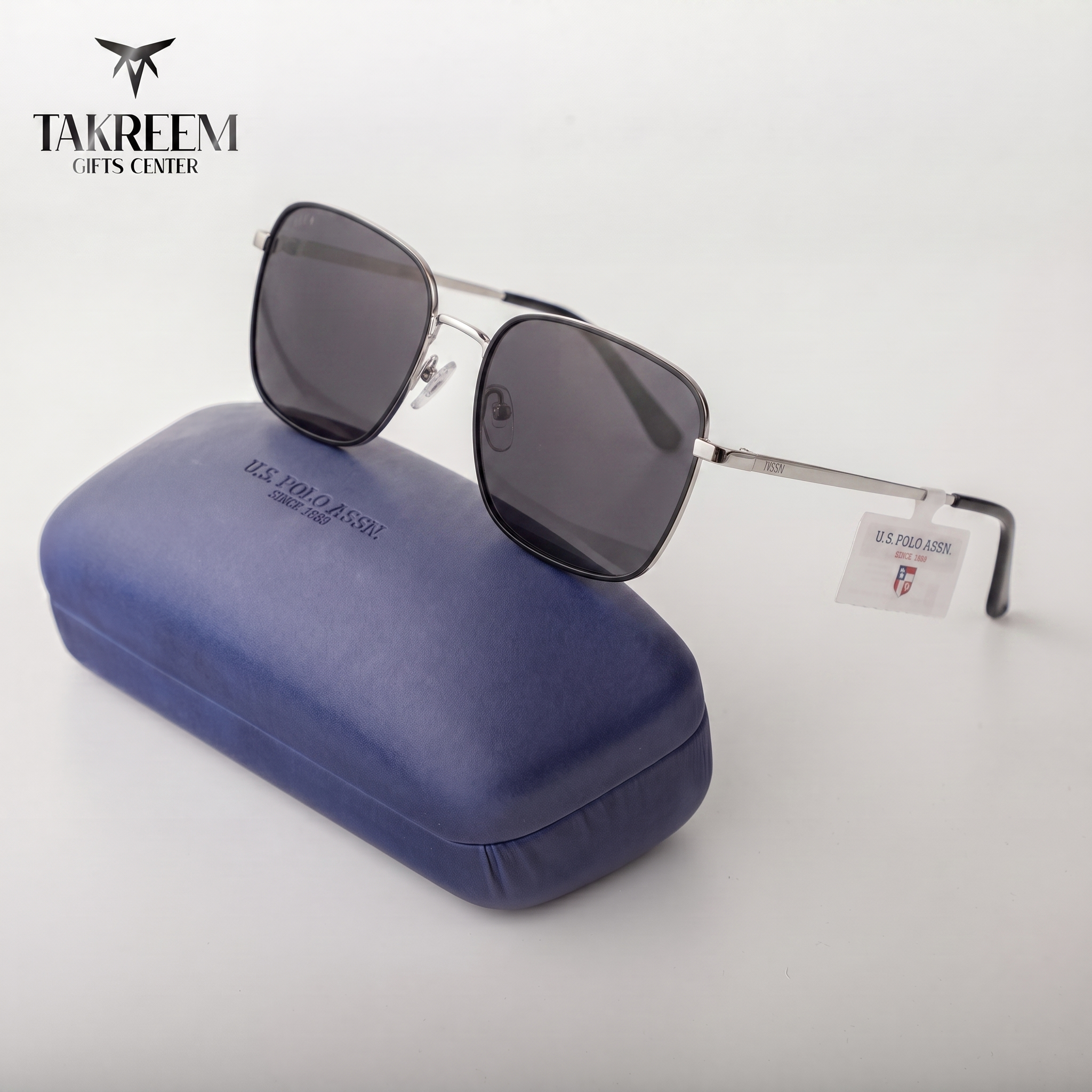 Sunglasses with a blue case on a light gray background, featuring the Takreem Gifts Center logo.